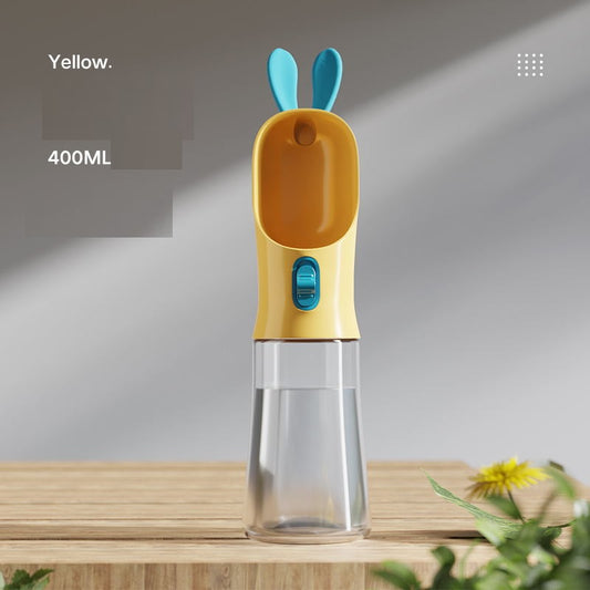 Squeezing the portable cup to pour fresh water for a dog on a walk